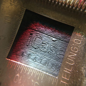 The iCase Leather logo seems melted into the material. Photo taken through a loupe.